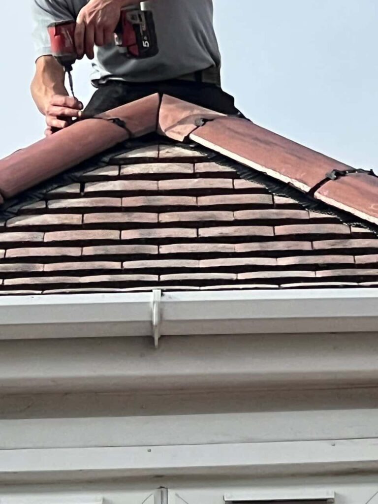 This is a photo of one of the operatives of Hassocks Roofing Repairs installing new ridge tiles